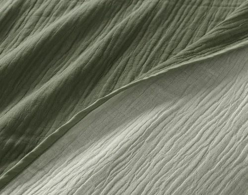 Close-up of our Leaf Bamboo Gauze Blanket to show its surface and off-colour reverse side-by-side.