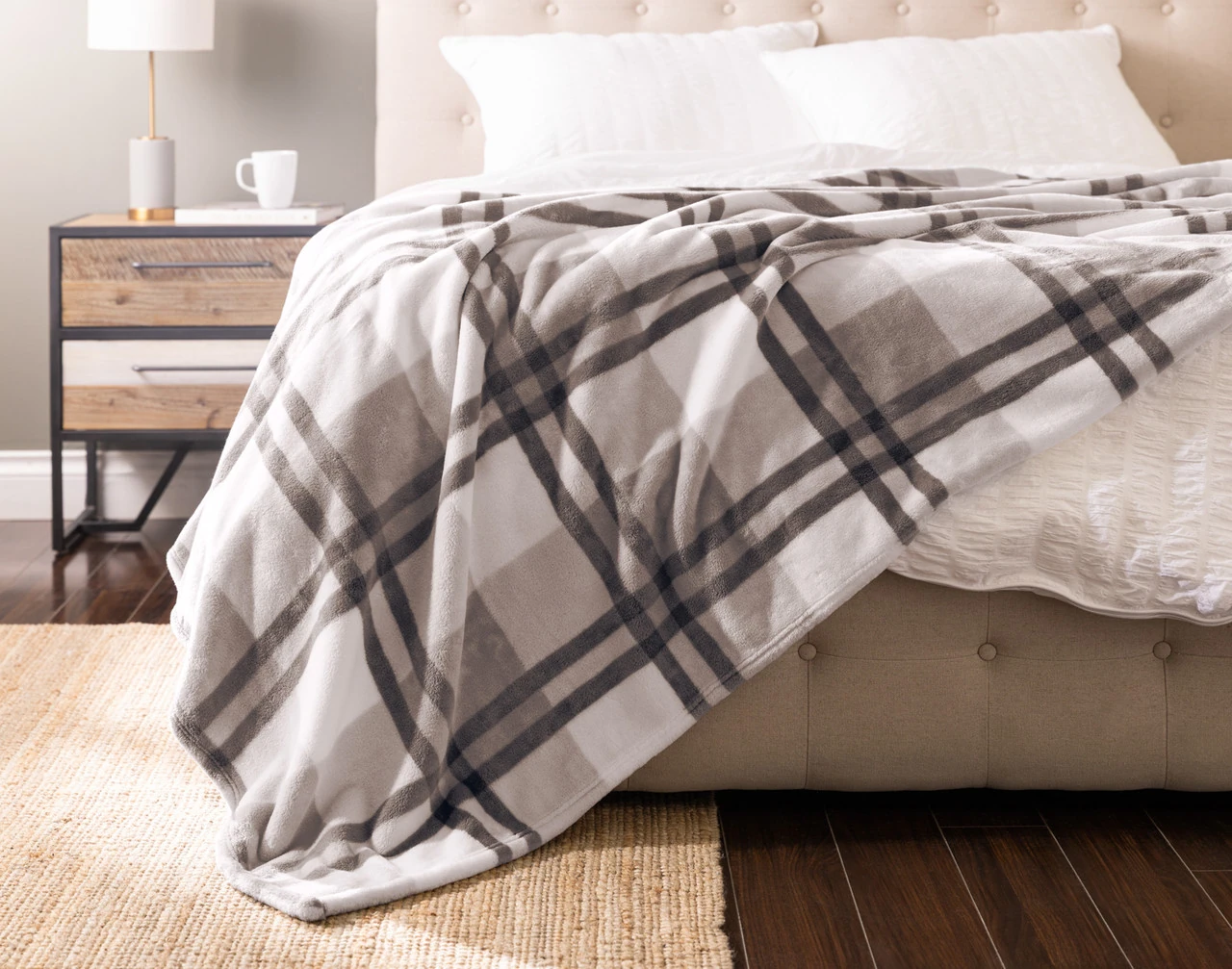 Front view of our Featherstone Plaid Blanket draped over a white bed.