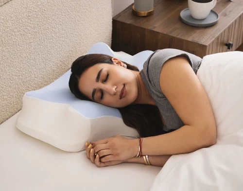 Woman resting comfortably on her side in bed on a Butterfly Memory Foam Pillow.