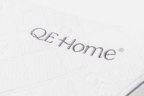 Close-up of the breathable bamboo blend cover and embroidered QE Home logo on our Butterfly Memory Foam Pillow.