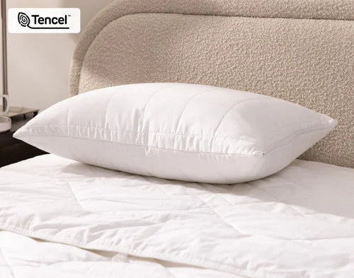Angled view of a pillow in our Ambience TENCEL™ Pillow Protector resting flat on a bed.