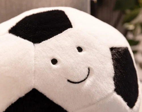 Close up on the smiling face of our Footy Soccer Ball Cushion.