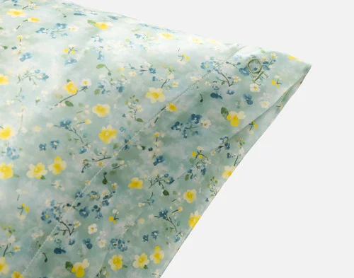 Close-up on the embroidered QE Home logo on the corner of our Mulberry Silk Pillowcase in Cadence.