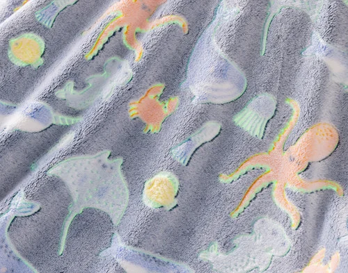 Close-up on the etched designs on our Under the Sea Glow In The Dark Throw with outlines to show its glowing spots.
