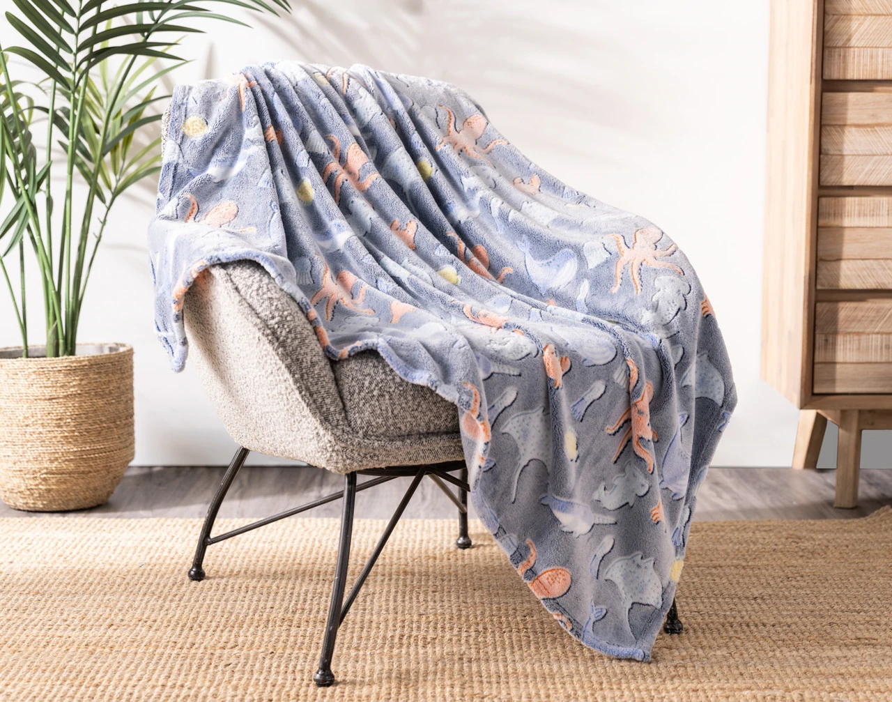 Angled view of our Under the Sea Glow In The Dark Throw draped over a chair.
