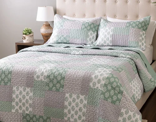 Angled view of our Nora Coverlet Set dressed over a plain queen bed.