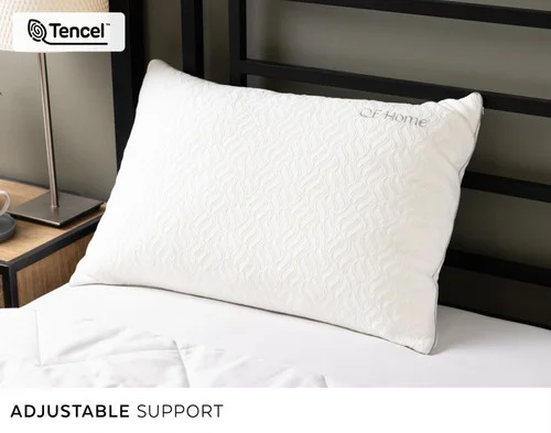 Our Deep Sleep Shredded Memory Foam & Lyocell Pillow leaning against a headboard.