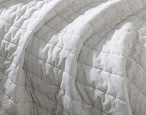 Close view of our Rove Quilt Set draping down the side of a queen mattress.