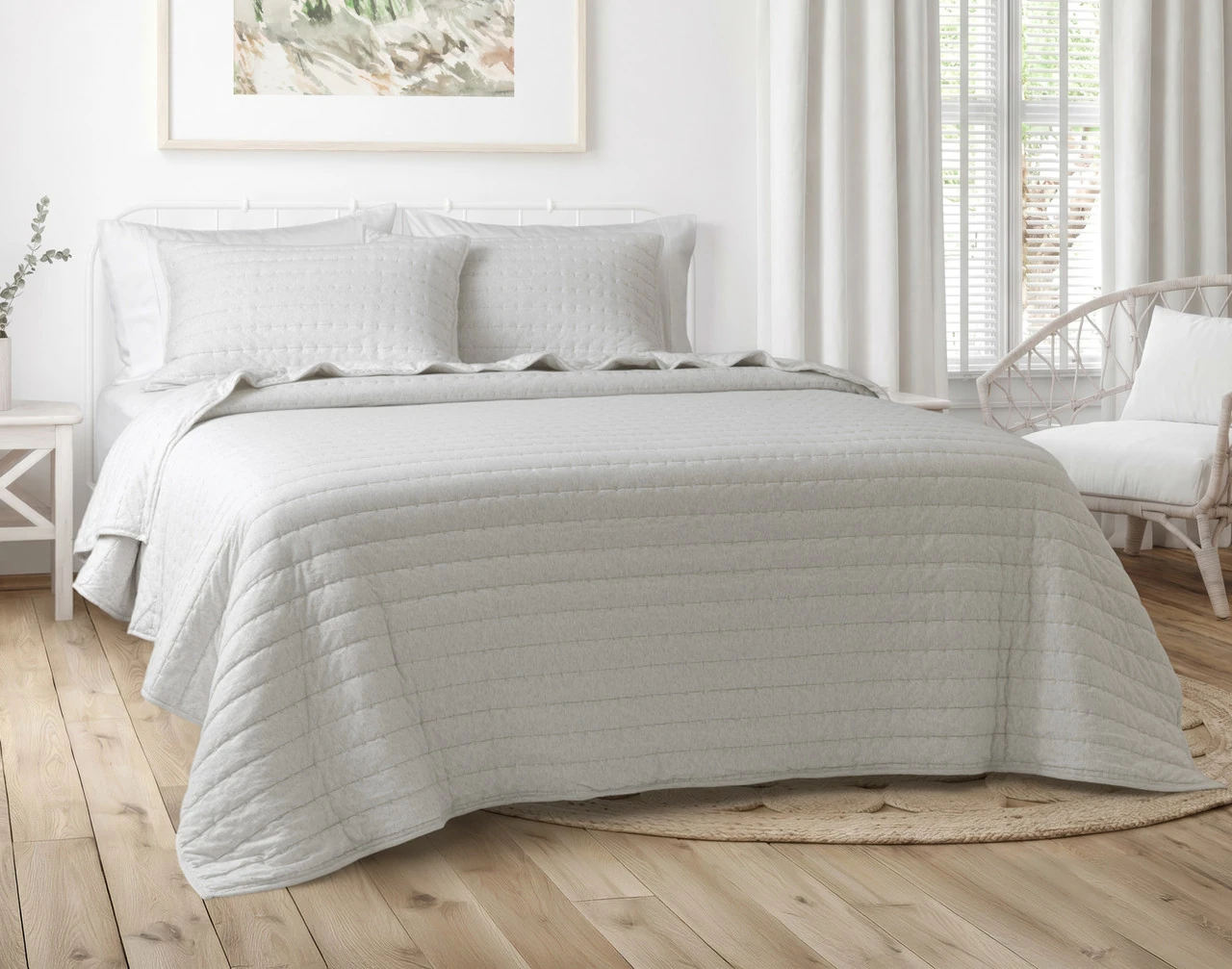 Our Rove Quilt Set dressing a queen bed in a simple grey bedroom.