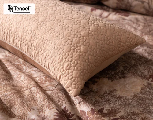 Close up on the corner of our Henan Leaf Boudoir Pillow Cover atop our Henna Leaf Duvet Cover.