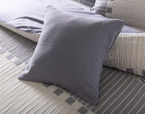 Our Rocco Square Cushion Cover resting on a bed.