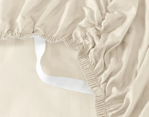 Close-up of the Stay Snug elastics on the loose corner of the fitted sheet for our Cream Luxor Egyptian Cotton Sheet Set.