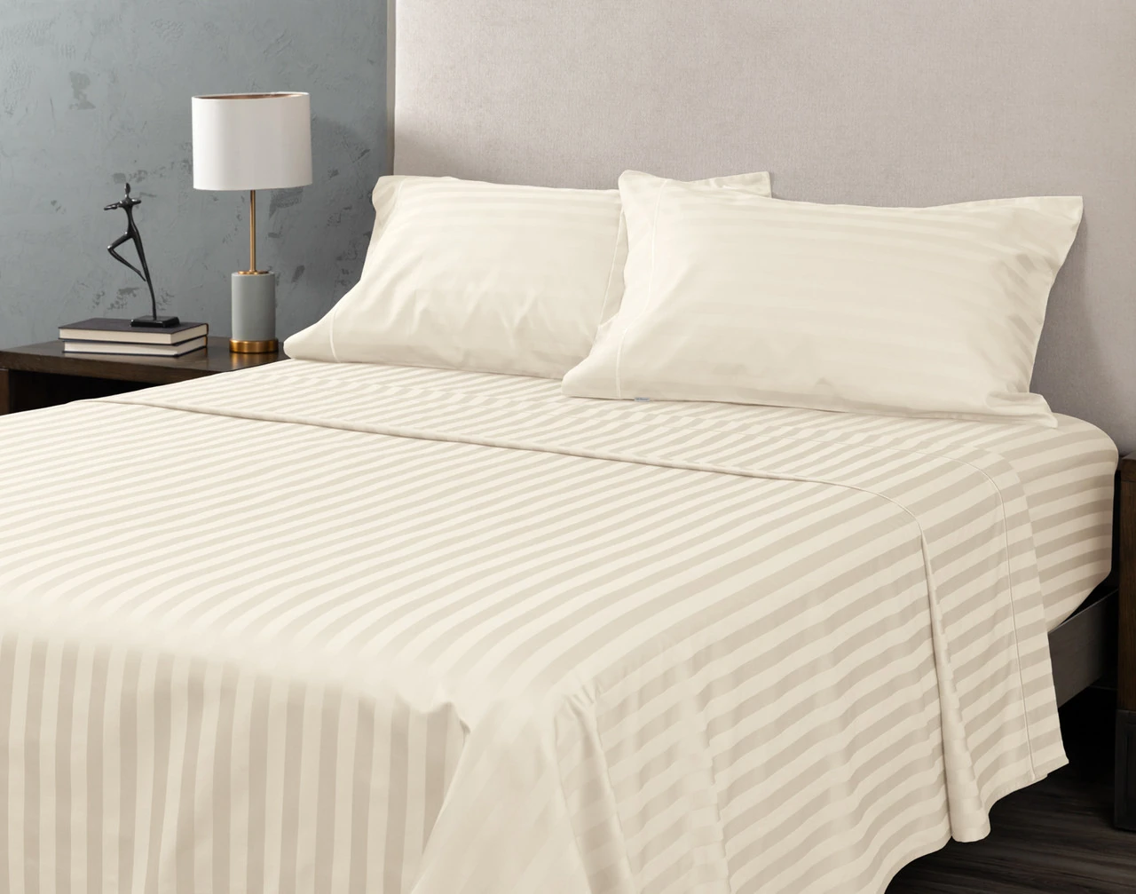 Angled view of our Cream Luxor Egyptian Cotton Sheet Set dressed over a plain queen bed.