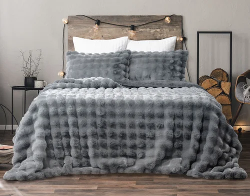 Front view of our Granite Bubble Faux Fur Comforter Set dressed on a cabin-style queen bed.