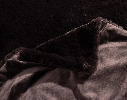 Folded corner of our Espresso Poodle Faux Fur Throw to show its front and reverse sides.