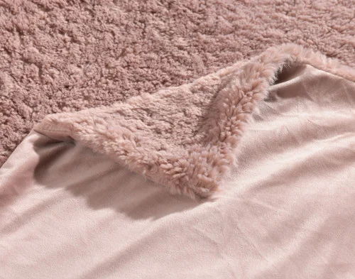 Folded corner of our Dusty Rose Poodle Faux Fur Throw to show its front and reverse sides.