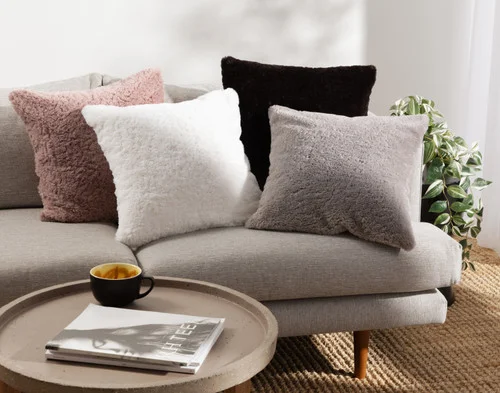Our Poodle Faux Fur Square Cushions sitting together on a couch.