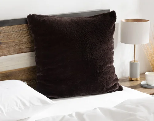 Angled view of our Espresso Poodle Faux Fur Euro Sham resting on a white bed.