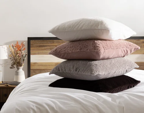 Our Poodle Faux Fur Euro Shams stacked on a white bed.