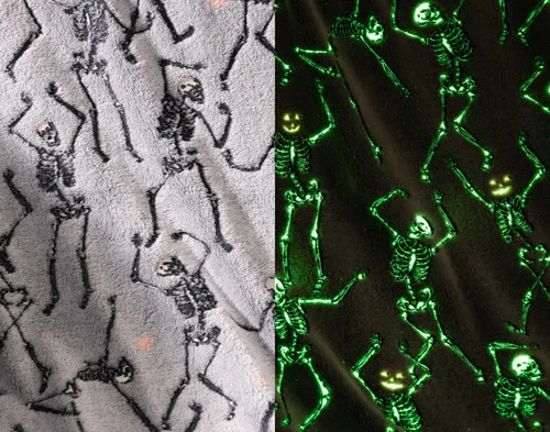 Side-by-side view of the soft fleece surface of our Skeleton Crew Glow in the Dark Fleece Throw in the light and while glowing in the dark.