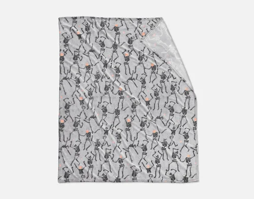 Folded view of our Skeleton Crew Glow in the Dark Fleece Throw on a white ground.