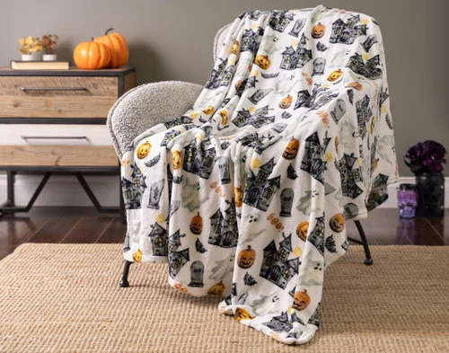 Our Haunted Mansion Halloween Fleece Throw draped over a chair.