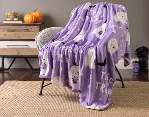 Our Trick or Treat Halloween Fleece Throw draped over a chair.
