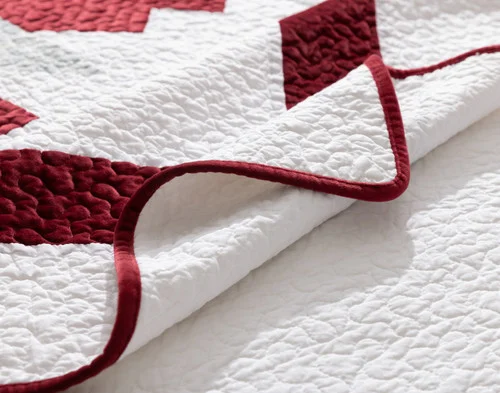 Folded edge and crimson piped border on our Noelle Wreath Quilt Set.