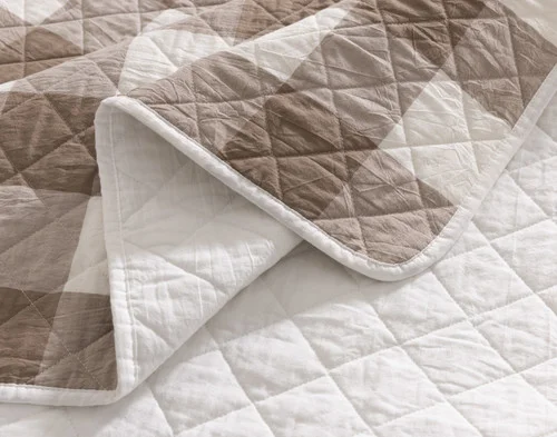Close-up of the greyish green gingham pattern and solid white reverse on our Wellington Ash Cotton Quilt Set.