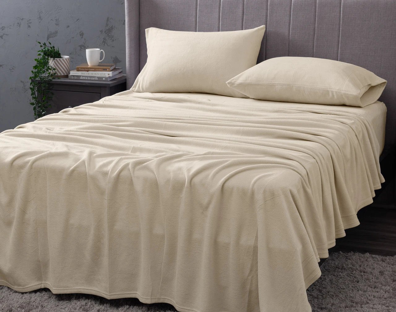 Angled view of our Cuddle Fleece Sheet Set in Oakwood fitted over a queen bed in a dark grey bedroom.