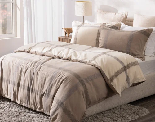 Angled view of our Bowen Duvet Cover Set dressing a queen bed in a simple modern room.
