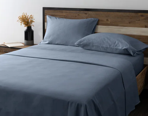 Angled view of our Arctic Slate Flannel Sheet Set dressed over an empty queen bed.