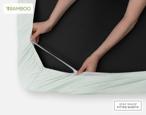 Our Bamboo Cotton Fitted Sheet in Aqua Smoke being fit over the corner of a mattress with its Stay Snug elastic.