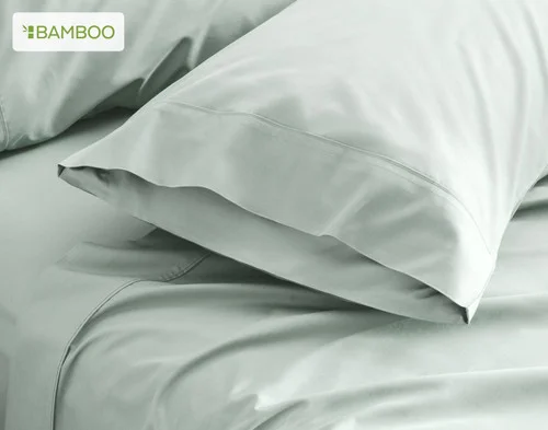 Our Bamboo Cotton Pillowcases in Aqua Smoke resting on a bed.