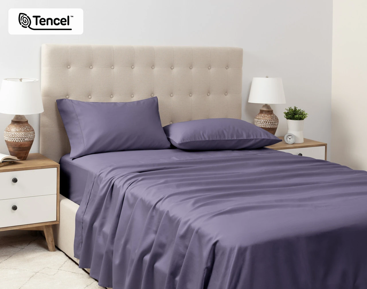 Angled view of a queen bed dressed in our Eucalyptus Luxe Sheet Set in Purple Basil.