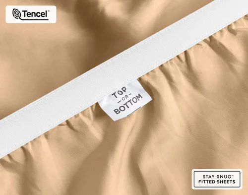 Close-up on the stretched elastic edge and tag stating "Top / Bottom" on our Eucalyptus Luxe Fitted Sheet in Sandalwood.