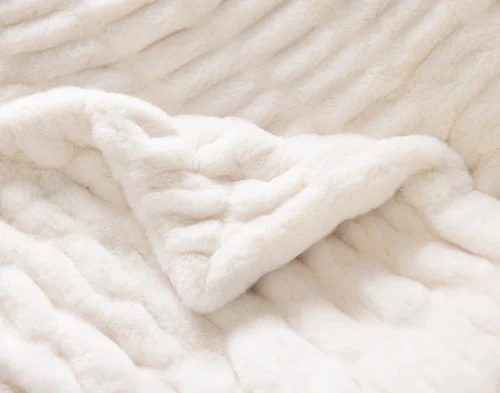 Close up on the folded surface of our Cocoon Plush Throw in Cream to show its textured surface.