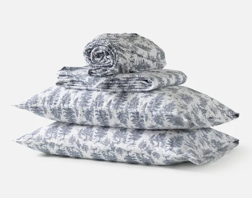 The contents of our Winter Toile Organic Cotton Flannel Sheet Set, including two pillowcases, a fitted sheet, and a flat sheet.