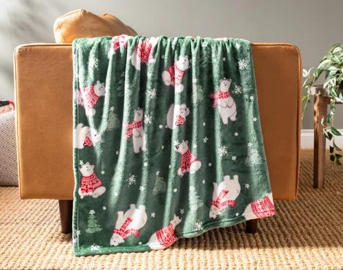 Our Holiday Fleece Throw - Snowy Bears draped over a brown couch.