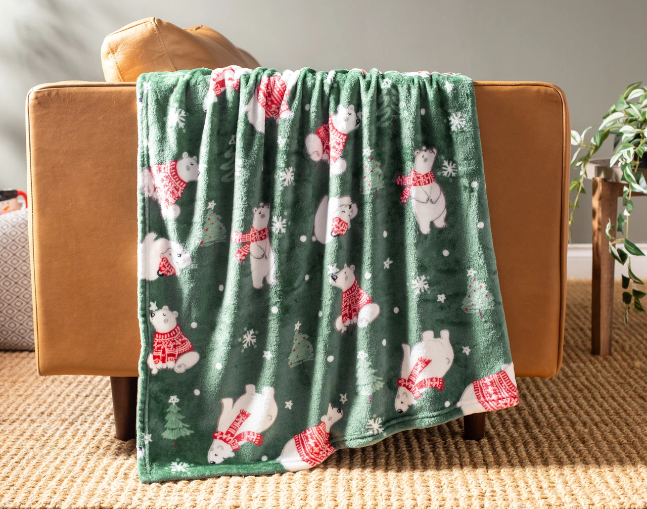 Our Holiday Fleece Throw - Snowy Bears draped over a brown couch.