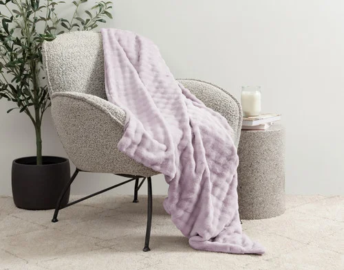 Our Lilac Dusk Mini Bubble Throw draped over a grey chair.