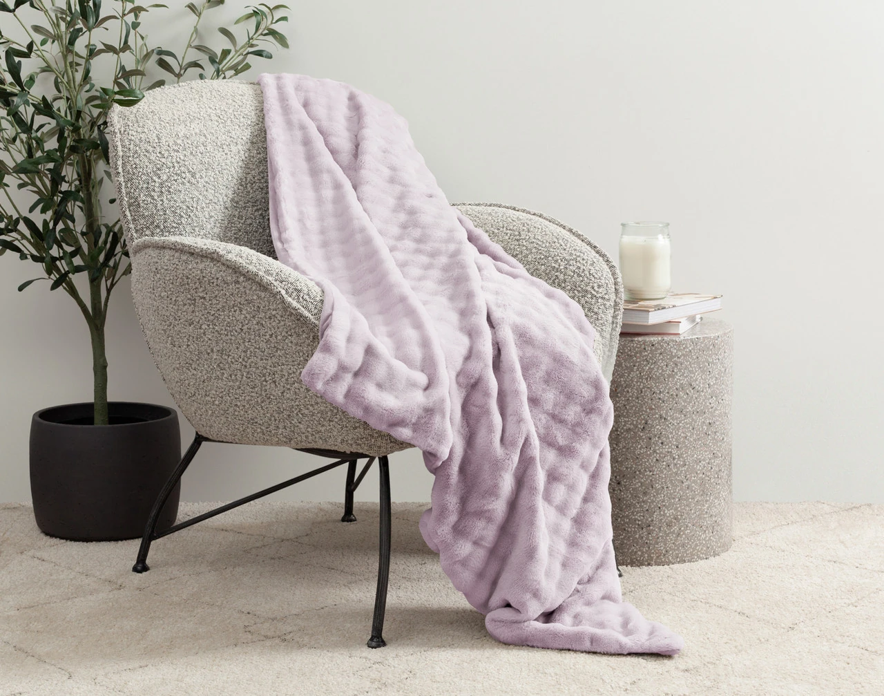 Our Lilac Dusk Mini Bubble Throw draped over a grey chair.