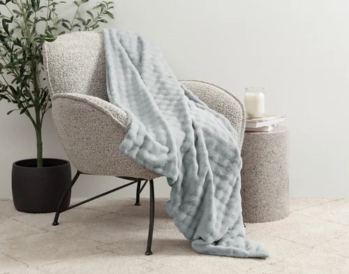Our Grey Dove Mini Bubble Throw draped over a grey chair.