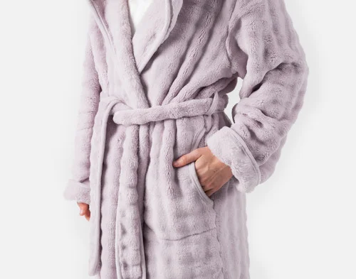 Woman putting her hand in the large side pocked on our Sage Mini Bubble Hooded Bathrobe.