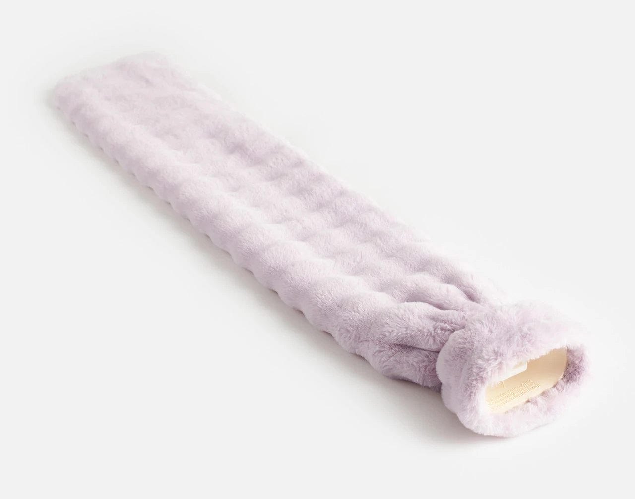 Angled view of our Lilac Dusk Mini Bubble Lumbar Hot Water Bottle laying flat on a white surface.