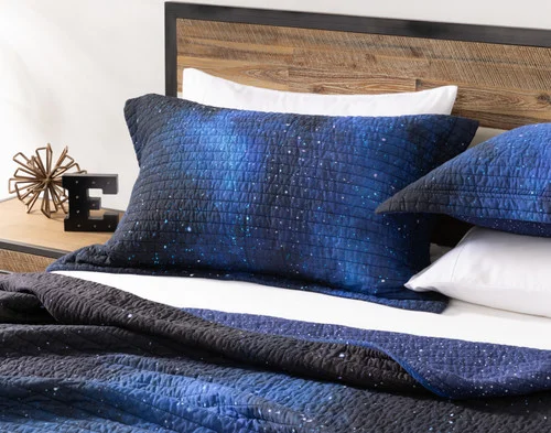 Angled view of a pillow sham from our Starfield Cotton Quilt Set resting on a bed.