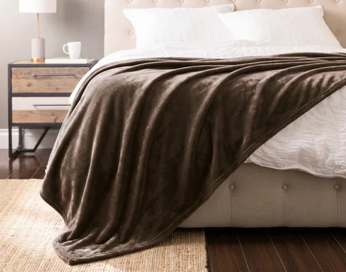 Front view of our Mink Cashmere Touch Blanket draped over a white bed.
