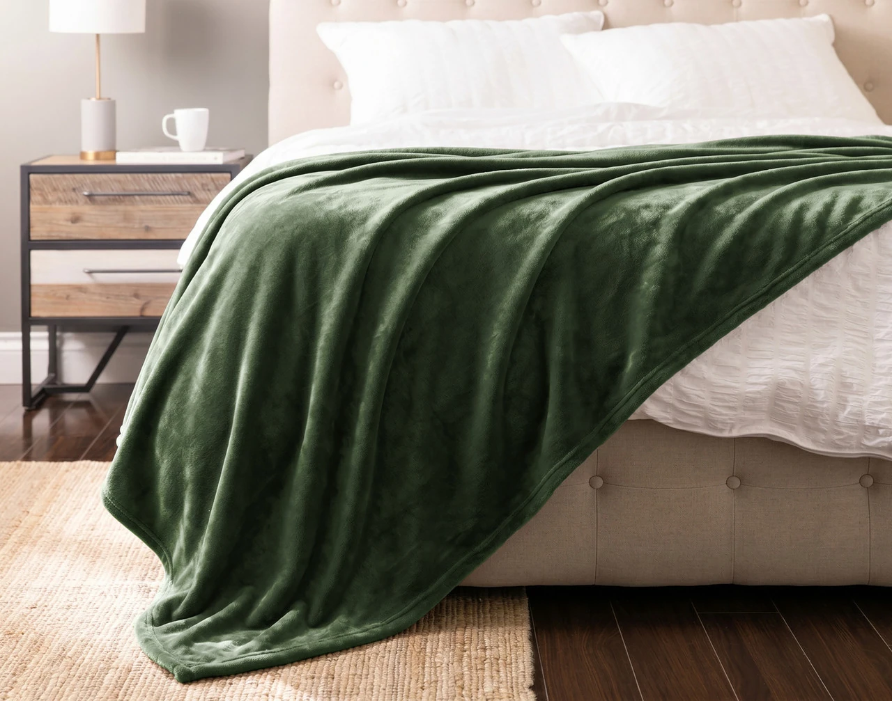 Front view of our Fir Cashmere Touch Blanket draped over a white bed.