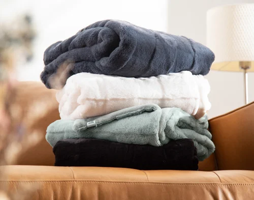 All of our Etched Check Throws piled on a couch.