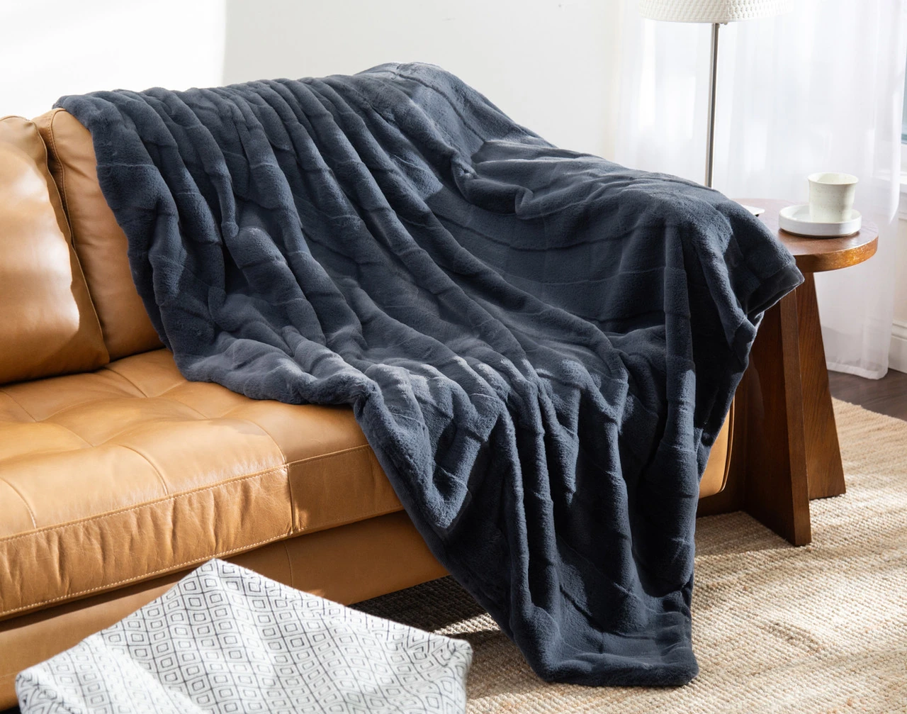 Our Etched Check Throw - Night Tide draped on a brown couch.